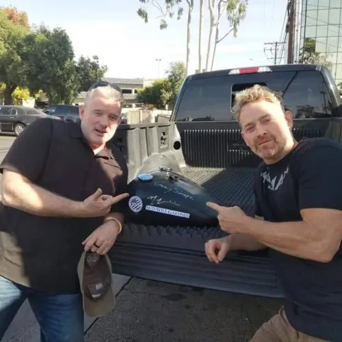 Max Martini signing the Custom Harley Tank