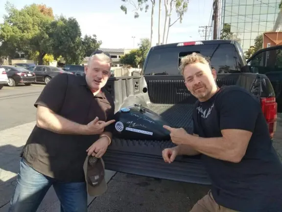 Max Martini signing the Custom Harley Tank